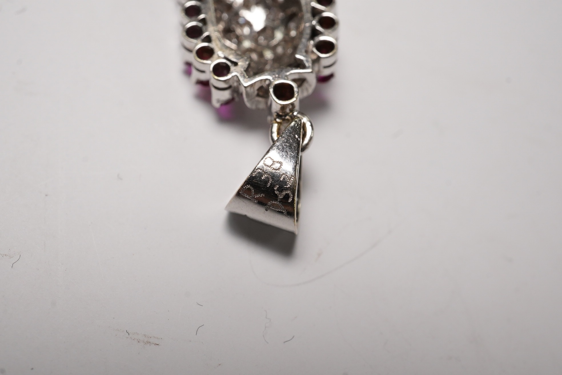 A white metal, diamond and ruby set pendant, 26mm and a pair of 9ct and diamond cluster set ear studs, gross weight 6.1 grams. Condition - fair to good